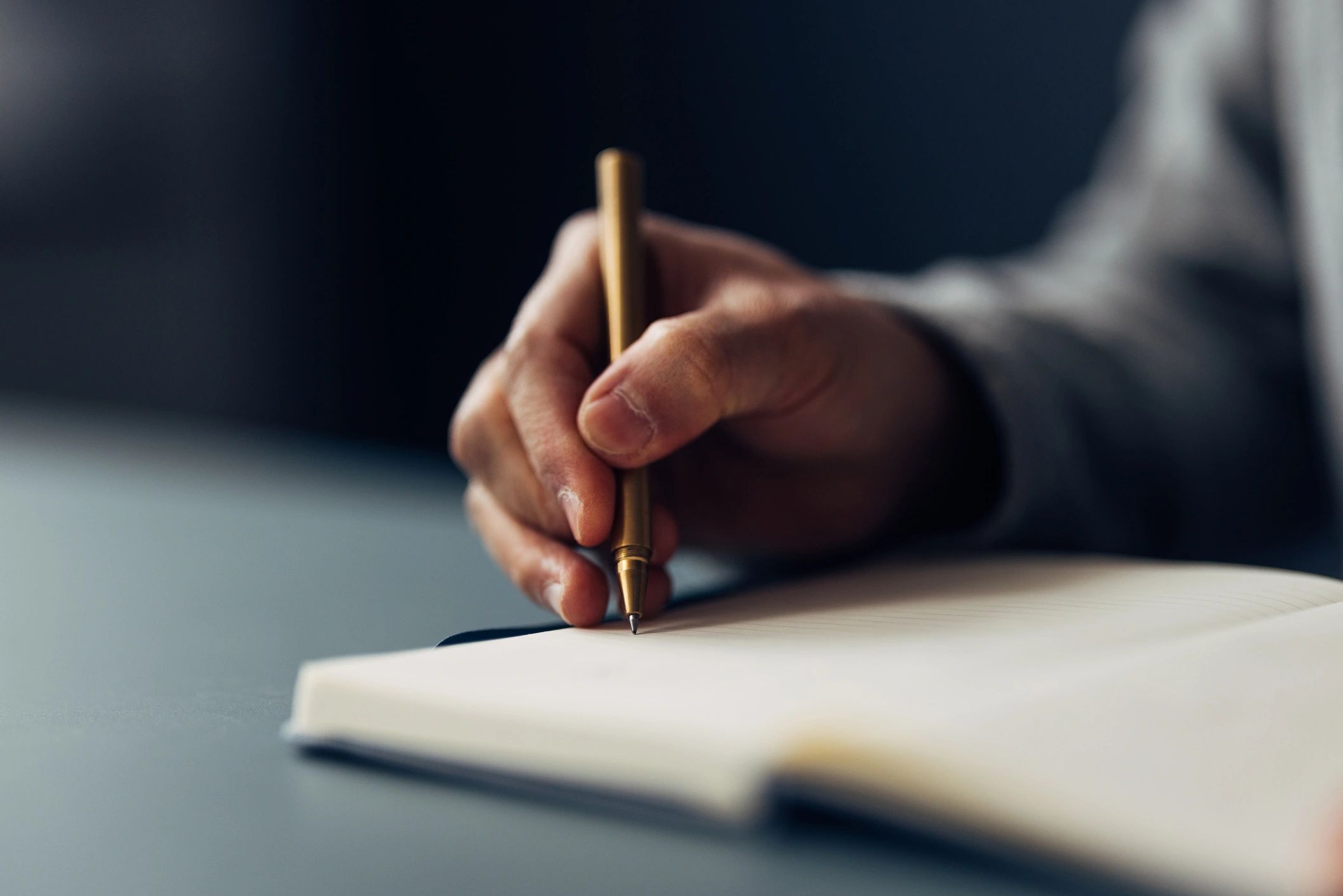 Hand writing in a notebook with a pen