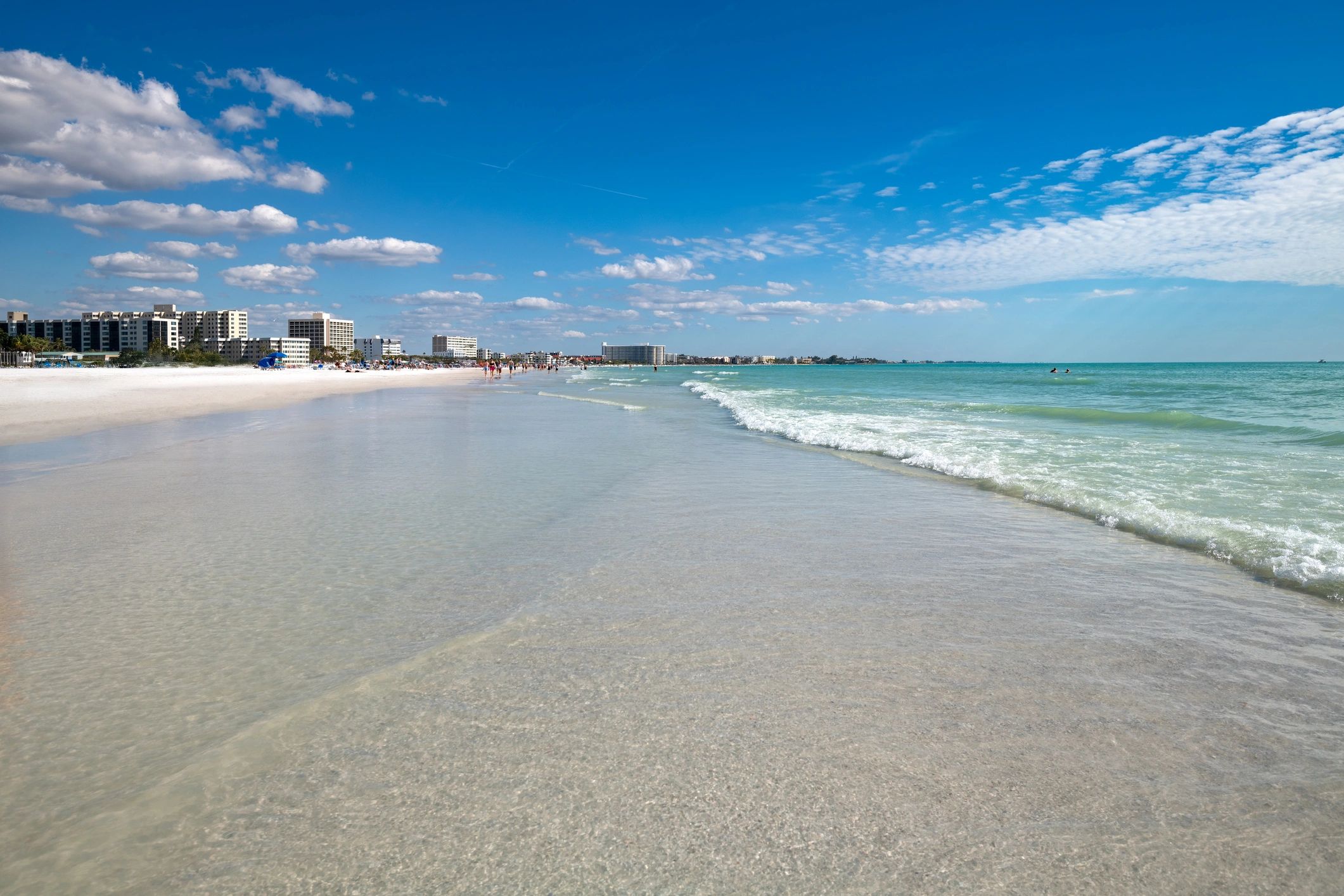 Wide view of a bright Florida beach with white sand and turquoise water