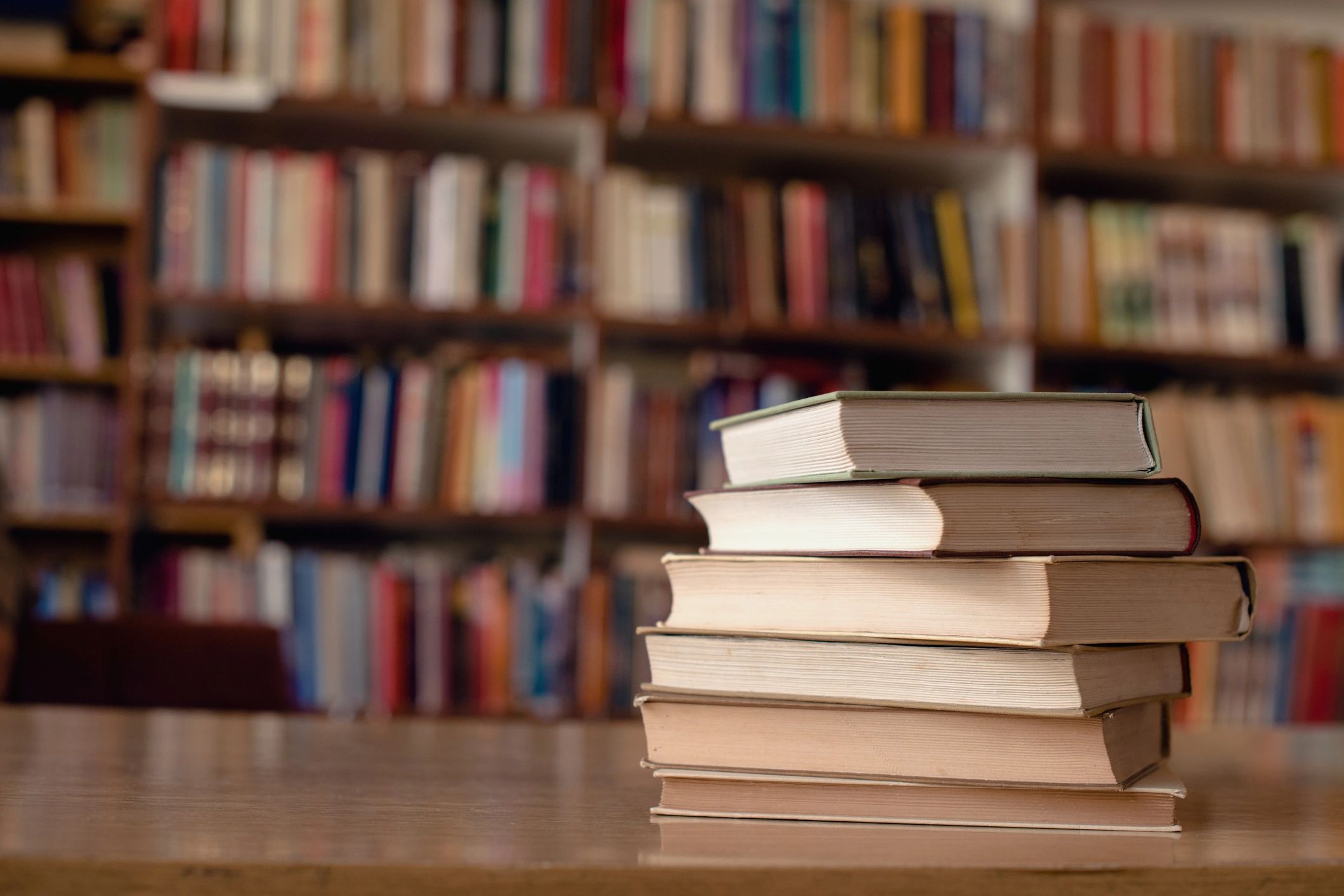 Stack of books on a desk in warm light